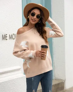 Stylish detail of an off-the-shoulder beige knitted sweater with white lightning patterns
