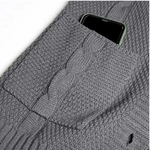 Detail shot of a grey cable-knit cardigan showing a functional large side pocket