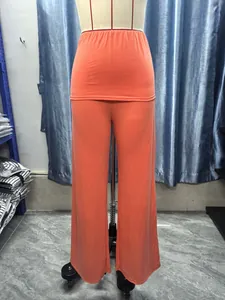 Detailed view of bright orange high-waisted wide-leg trousers on a mannequin