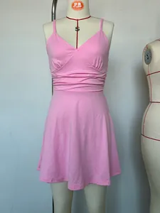 Close-up detail of pink V-neck slip dress featuring elegant pleated waist design