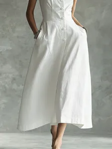 Detail view of a white button-down midi dress with flared skirt and side pockets for summer