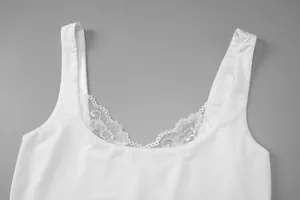Gros plan détaillé de la dentelle florale sur un débardeur blanc à col rond mode