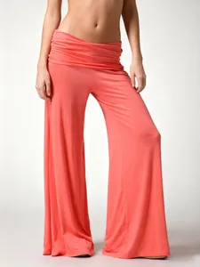 Detail shot of high-waist coral pink wide-leg yoga pants with pleated waistband.