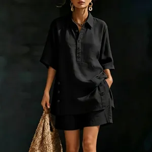 Dettaglio del completo nero in lino con camicia a bottoni e pantaloncini morbidi.
