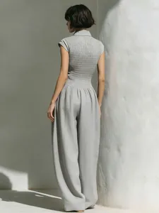 Back view of a grey sleeveless jumpsuit with smocked bodice and wide-leg trousers