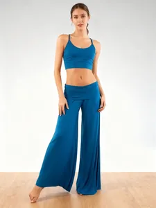 Detail view of stylish blue wide-leg yoga pants and matching sports bra set on a model.