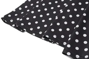 Close-up macro detail of a black and white polka dot dress hem with neat double stitching