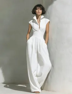 Elegant white sleeveless jumpsuit featuring deep V-neck and high collar detail in sunlight