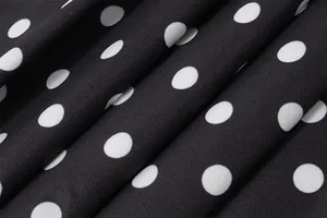 Close-up detail of black and white polka dot fabric texture for elegant dress