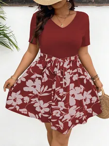 Detailed front view of a plus-size V-neck floral print dress featuring a chic tie-waist design