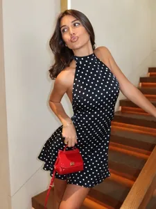 Close-up of a stylish black and white polka dot backless halter dress on a model