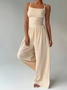 Detail view of a beige summer jumpsuit featuring a wrap-waist and flowing wide-leg cut.