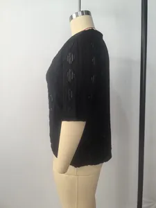 Detailansicht der Seite einer schwarzen Damen-Strickjacke in Übergröße mit Lochmuster