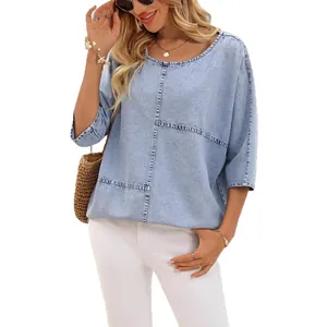 Dettaglio di una t-shirt in maglia celeste effetto denim con cuciture decorative.
