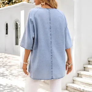 Vista posteriore dettagliata di una tunica in denim blu chiaro oversize alla moda