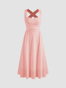 Robe midi rose élégante de style français, coupe trapèze avec bretelles croisées, vue de face.