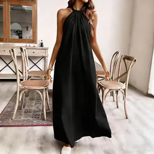 Detailansicht eines eleganten schwarzen Neckholder-Maxikleids in gemütlicher Umgebung