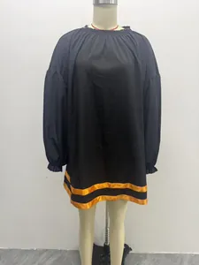 Full view of black puff sleeve dress on a mannequin with orange stripe hem detail.