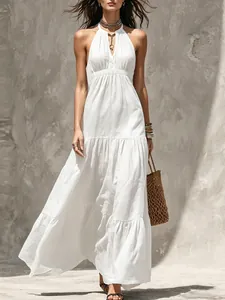 Dettaglio di un vestito lungo bianco con scollo halter e gonna a balze per l'estate.