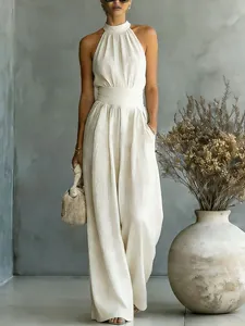 Elegante mono beige con cuello halter, pernera ancha y diseño entallado para un estilo chic.