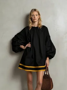 Loose black puff-sleeve doll dress featuring bold yellow stripes on the lower hemline