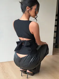 Back view of a black sleeveless top featuring a large bow-tie and open-back detail