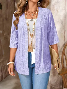Detailansicht eines lila Damenstrick-Cardigans mit Häkelmuster und Boho-Accessoires