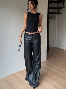 Close-up detail of a chic black sleeveless slim fit vest paired with stylish faux leather pants
