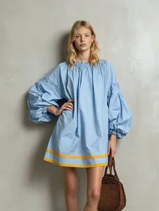 Full-body view of a light blue puff sleeve babydoll dress with yellow contrast striped hem.