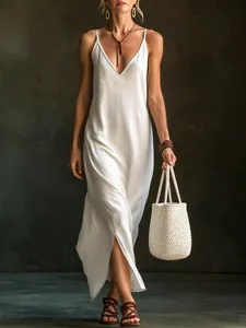 Model wearing a white V-neck sleeveless slit maxi dress in a bohemian vacation style