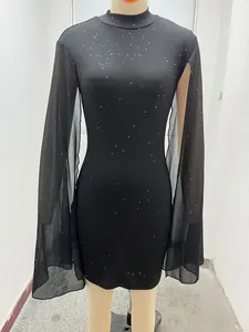 Detail of black rib-knit bodycon dress with shimmering pearl dots and chiffon cape.