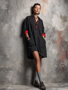 Schwarzes Hemdkleid mit kontrastierenden roten Manschetten an einem Model im Studio.