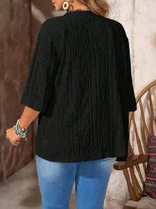 Rückenansicht eines schwarzen Cardigans in Übergröße mit Rauten-Durchbruchmuster.