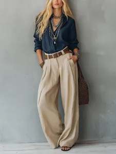 Chic high-waisted beige wide-leg trousers paired with a navy shirt for a relaxed look