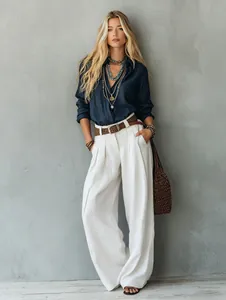 Full view of elegant high-waisted white wide-leg trousers with flowy fabric detail