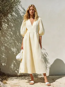 Detailed view of the elegant V-neck and puff sleeve design on this yellow dress.
