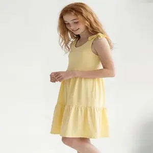 Detailed side view of a girls' yellow sleeveless tiered dress with cute shoulder ties.