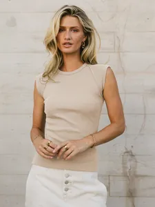 High-quality detail of a slim fit beige ribbed knit sleeveless tank top on a female model