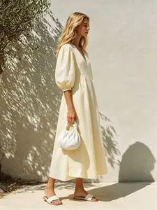Elegant pale yellow V-neck midi dress with puff sleeves for a breezy summer look