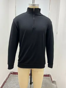 Detailed view of men's minimalist black long-sleeve quarter-zip polo shirt on mannequin