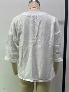 Detailed back view of a white loose-fitting casual women blouse displayed on a mannequin