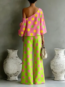 Vista posteriore di una modella in top rosa monospalla a pois e pantaloni verdi larghi