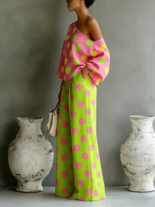 Donna alla moda in completo con top a pois rosa e verdi e pantaloni a gamba larga