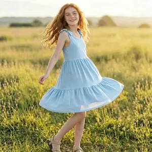 Light blue sleeveless summer dress for girls featuring tie-shoulder straps in a field