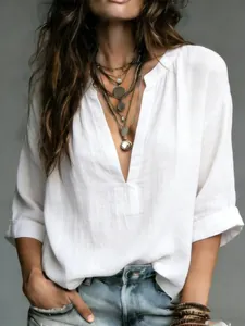 Close-up of a white linen-style V-neck blouse with rolled sleeves for a casual bohemian look