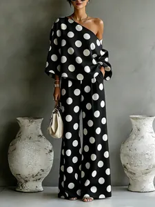 Elegante completo a pois bianco e nero con top monospalla e pantaloni a gamba larga