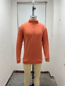 Detail of orange half-zip long sleeve polo shirt on a mannequin for autumn wear