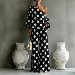 Elegante set due pezzi a pois bianco e nero con maglia monospalla e pantaloni a palazzo
