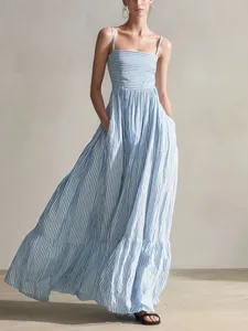 Elegante abito lungo a righe bianche e blu con spalline sottili e comode tasche