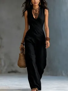 Foto de moda de un elegante conjunto de top negro con cuello en V cruzado y pantalones anchos
